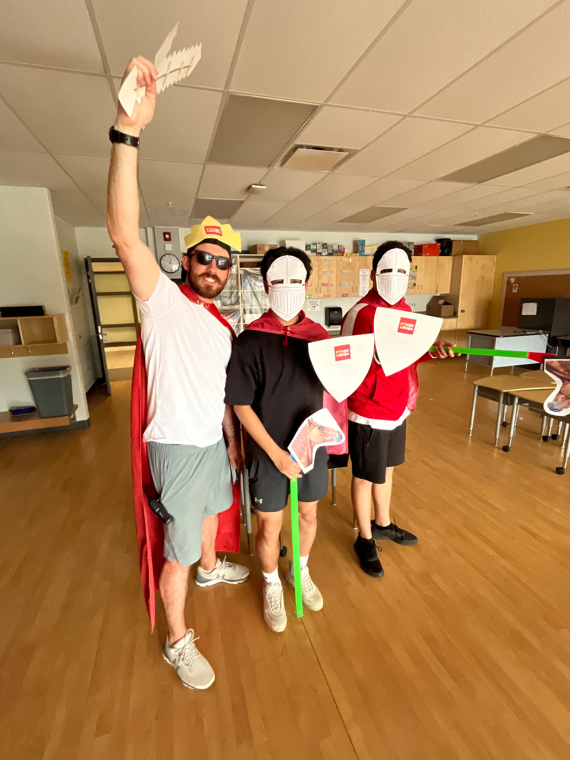 A team of Rouge Camps Woodbridge directors pose in medieval knight costumes, before acting in a camp wide activity skit.