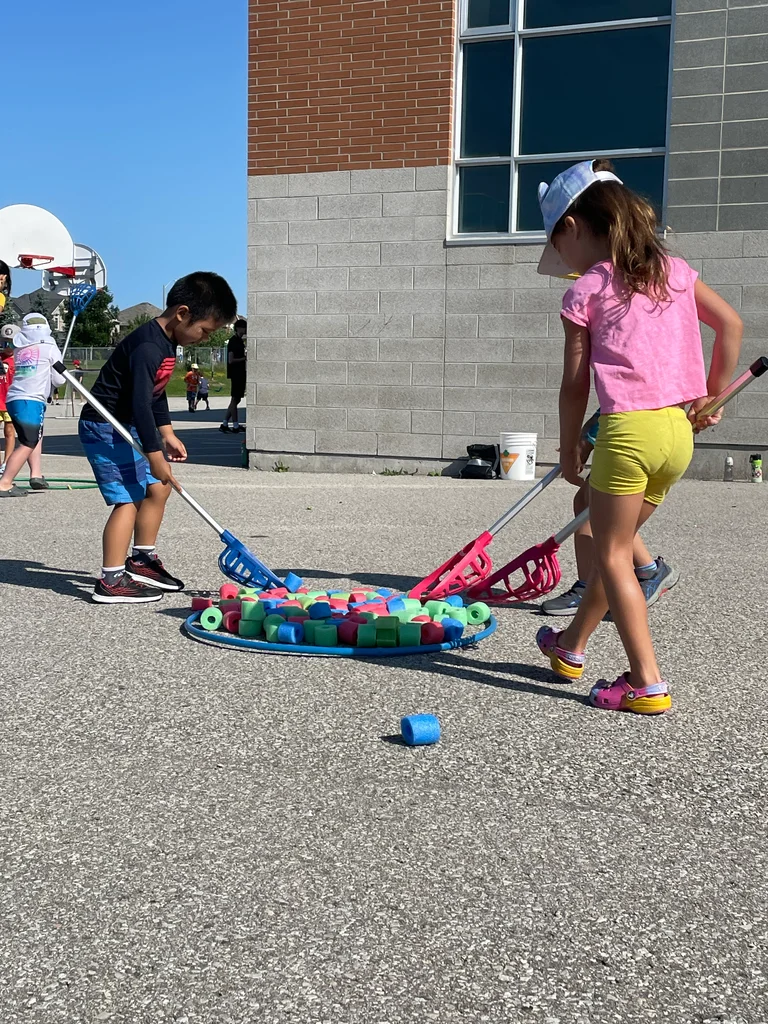 Deer campers use lacrosse sticks to scoop up bits of colourful pool noodles at Rouge Camps.