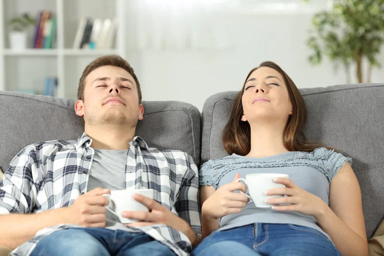 Parents relaxing on the couch having a coffee while their kids are enriching themselves at Rouge Camps.