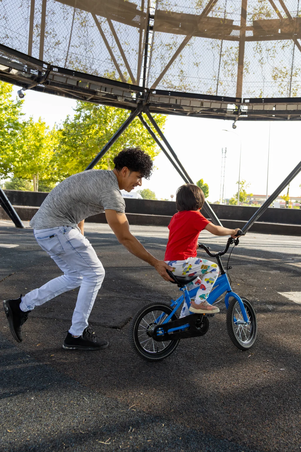 father-helping-son-riding-bicycle-in-a-city-park