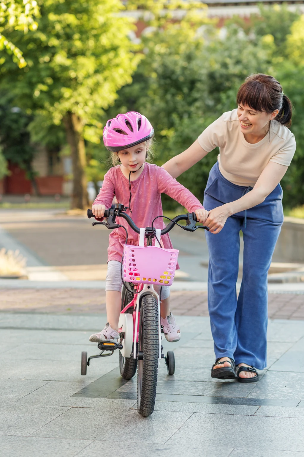 mother-helping-her-young-daughter-ride-a-bicycle-i-2026